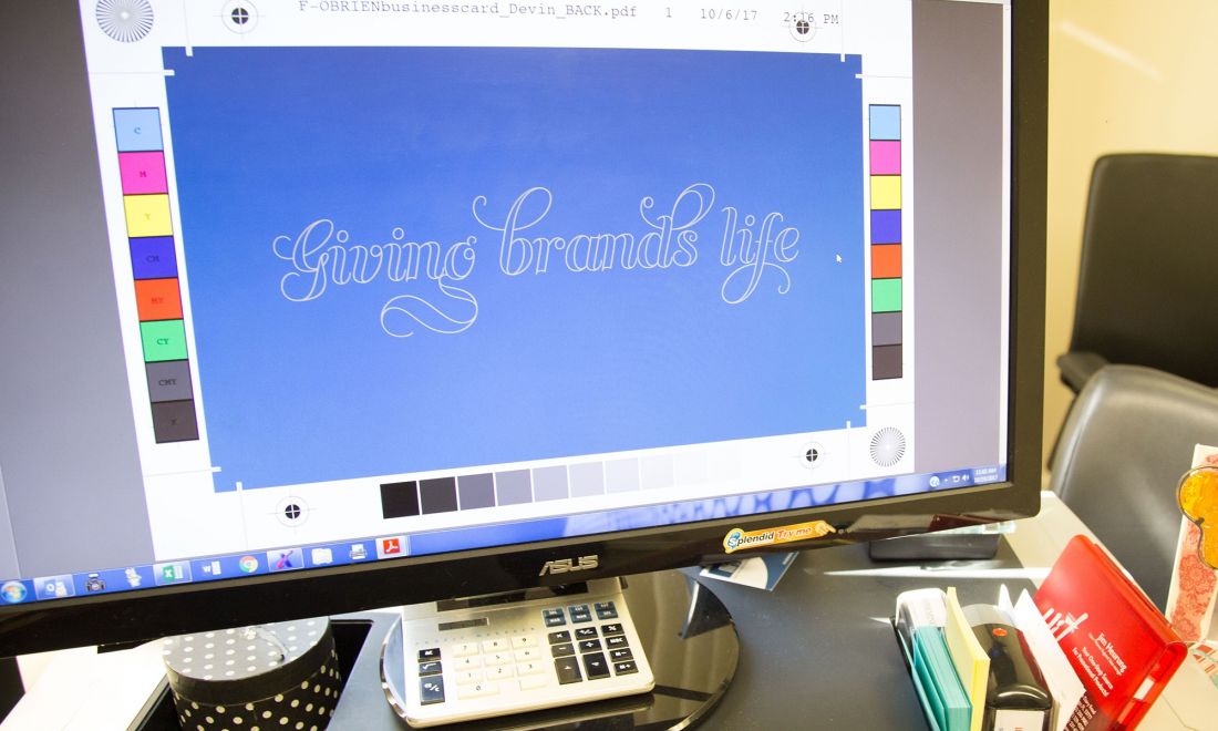 A desktop computer displaying the O'Brien slogan giving brands life on a design editing software.