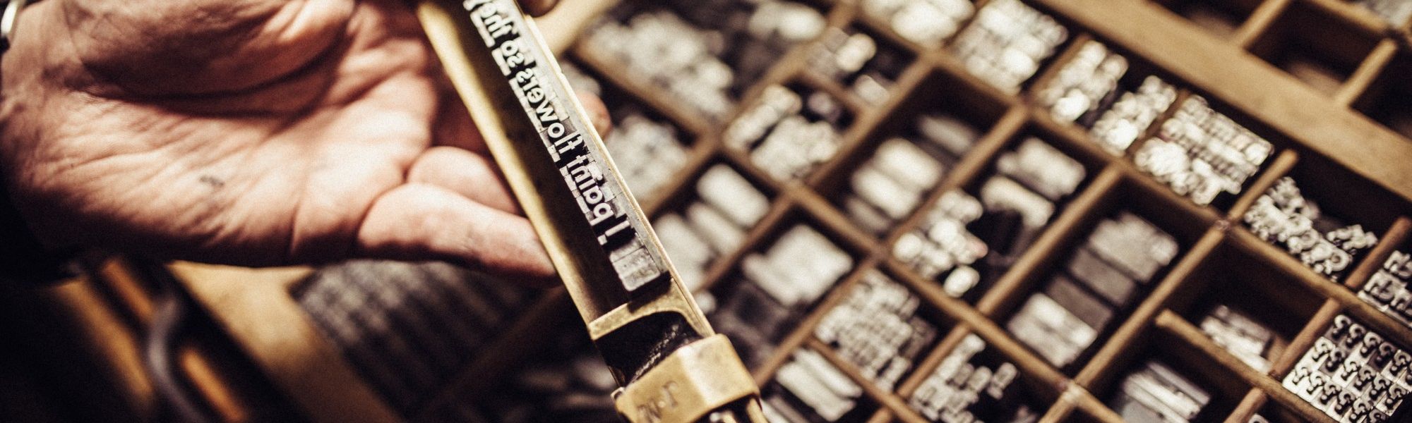 a man holding letters that would be placed into a screen printer.