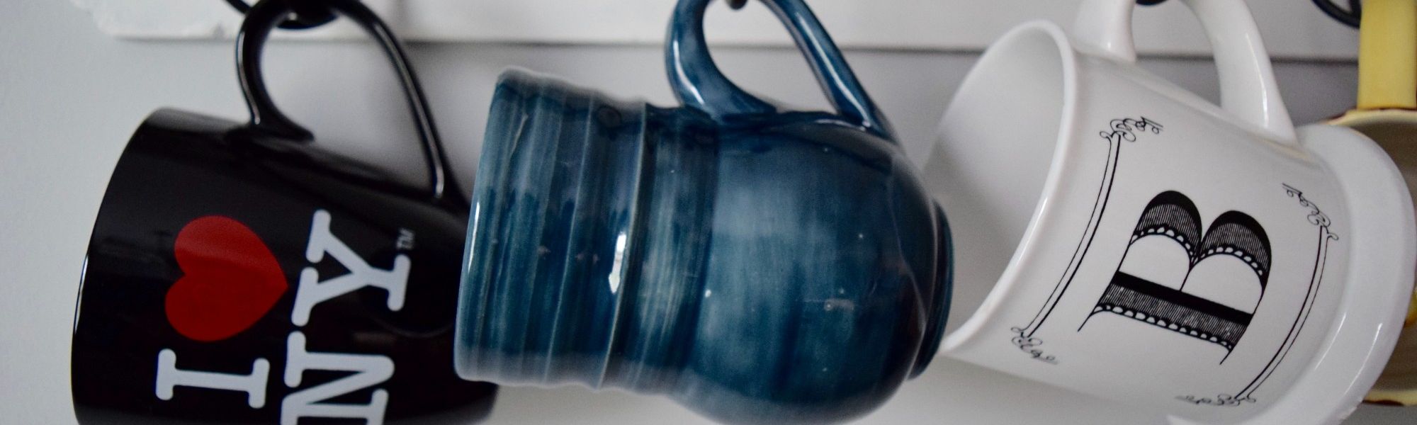 Three mugs hanging on a holder.