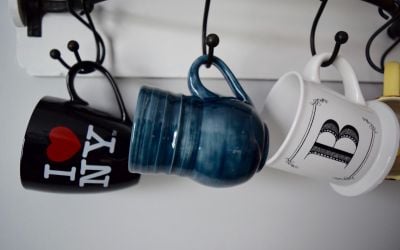 Three mugs hanging on a holder. 